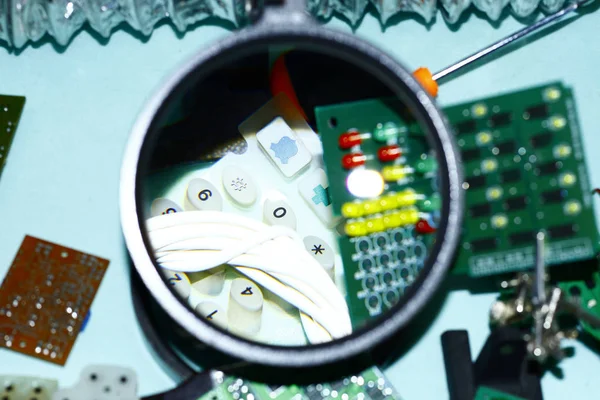 Elektronik bileşenleri devre kartlarına Büyüteç ön planda ile basılmış.