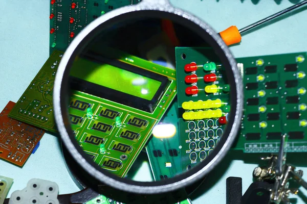 Elektronik bileşenleri devre kartlarına Büyüteç ön planda ile basılmış.