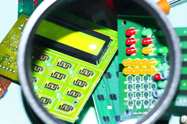 Elektronik bileşenleri devre kartlarına Büyüteç ön planda ile basılmış.