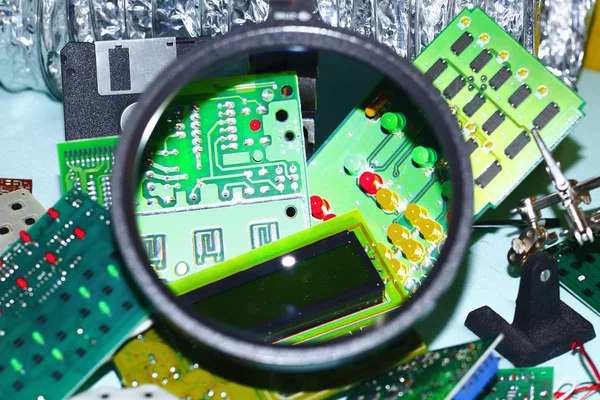 Elektronik bileşenleri devre kartlarına Büyüteç ön planda ile basılmış.