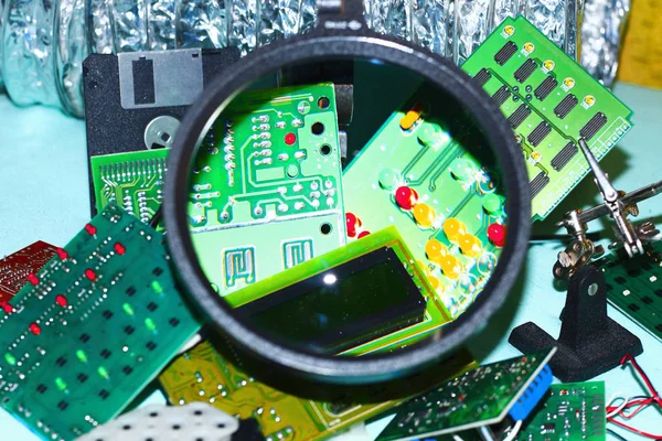 Elektronik bileşenleri devre kartlarına Büyüteç ön planda ile basılmış.