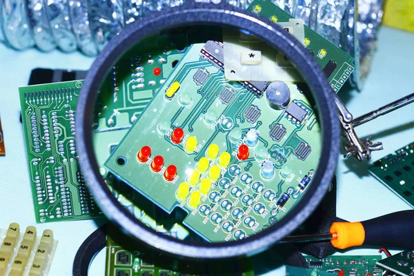 Elektronik bileşenleri devre kartlarına Büyüteç ön planda ile basılmış.