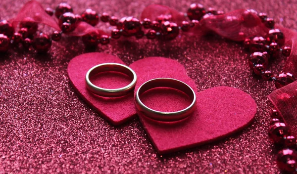 Red background with two rings lies on two hearts