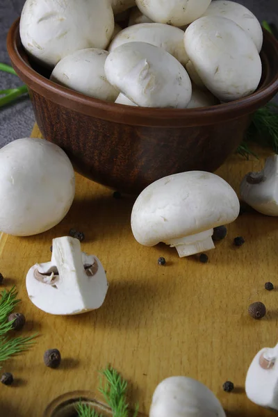 Horizontal close-up of champignon mushrooms, which lie on the table and in the plate — Stock Image Horizontal Close Champignon Mushrooms Which Lie Table Plate Royalty Free Stock Photos