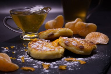 Sağlıklı, ev yapımı yemek. Taze ev yapımı peynir üzerinden kuru üzüm ile peynir kek yaptı. Pudra şekeri, dilim mandalina ve bal