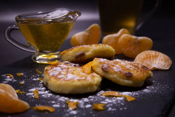 Sağlıklı, ev yapımı yemek. Taze ev yapımı peynir üzerinden kuru üzüm ile peynir kek yaptı. Pudra şekeri, dilim mandalina ve bal