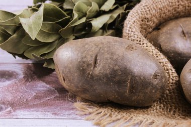 Patates üzerinde yakın çekim, hangi bir buket defne yaprağı yanındaki masada yalan. Patates püresi hazırlanması için malzemeler. Baharat