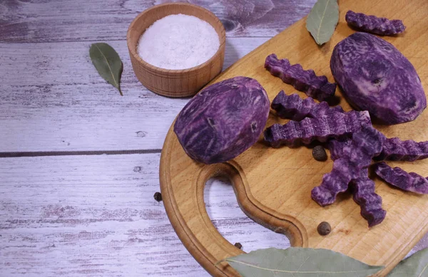 üstüne mor patates dalgalı dilim dilimlenmiş planlayın. Dekoratif Yemek tasarım. defne yaprağı, baharatlar. Girişler için boş alan