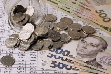 500 Grivnası Banknotlar yakın çekim numaraları ile tablolar üzerinde. 2 Grivnası bir yüz değeri ile sikke bir cam kumbara, Ukrayna Grivnası dağılmış.