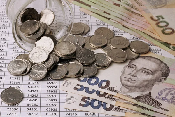 500 Grivnası Banknotlar yakın çekim numaraları ile tablolar üzerinde. 2 Grivnası bir yüz değeri ile sikke bir cam kumbara, Ukrayna Grivnası dağılmış.