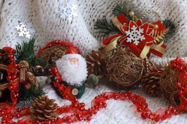 Yeni yıl oyuncakları, Noel Baba, kırmızı boncuk ve kar taneleri asmak beyaz örme arka plan üzerinde bir Noel ağacıdalları yatay büyük görünümü