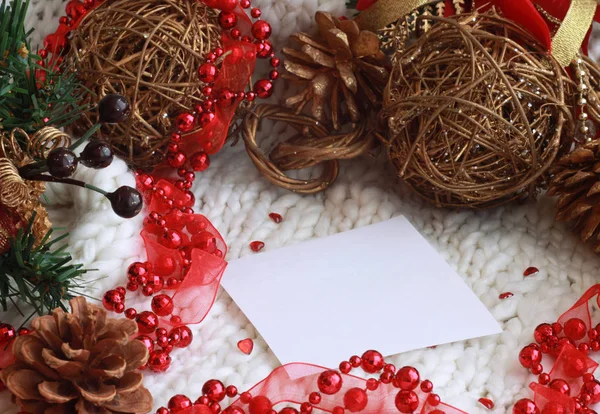 Weihnachtsfestliches Saisonbild in rot und weiß mit weißem Plattenblatt in der Mitte, Weihnachtsspielzeug, grünen Fichtenzweigen, roten Perlen und Herzen. 2019 — Stockfoto