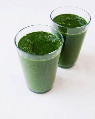 Ispanak, muz, spirulina, hindistan cevizi sütü ve keten tohumu ile taze harmanlanmış yeşil smoothie . Sağlıklı çiğ gıda