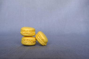 Gri arka planda taze lezzetli sarı Makaron yığını. Fransız pastane, tatlı yemek. Boşluk Kopyala
