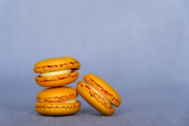 Gri arka planda taze lezzetli turuncu Makaron sandviç kurabiye yığını, yakın. Boşluk Kopyala. Fransız şekerleme