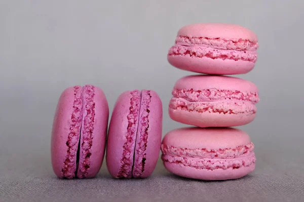 Stack of delicious french pink fruity flavour macarons on grey background