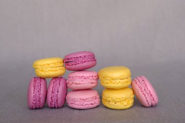 Gri arka plan üzerinde çeşitli renkli lezzetli fransız makarnalar. Tatlı yemek