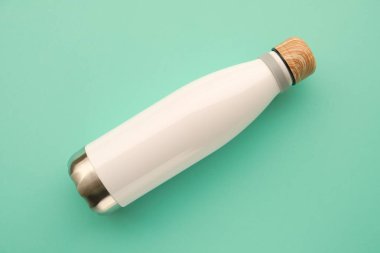 Reusable eco friendly sustainable water bottle on mint background.