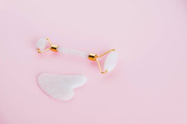 Pembe arka planda pembe kuvarstan yapılmış yeşil taş silindirli..