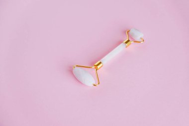 Pembe arka planda pembe kuvarstan yapılmış yeşil taş silindirli..