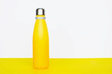 Sarı arka planda yeniden kullanılabilen paslanmaz çelik termo şişe. Uzayı kopyala Sıfır atık, plastiksiz, sürdürülebilir yaşam tarzı konsepti.