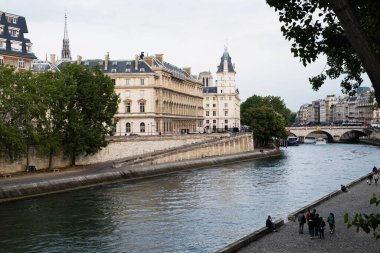Gün batımında Seine nehrinin yanında güzel binaları olan Paris şehri manzarası.