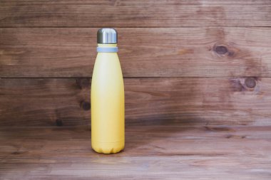 Ahşap kırsal arka planda yeniden kullanılabilir çevre dostu, paslanmaz çelik termo şişe. Uzayı kopyala Sıfır atık, plastik yok, sürdürülebilirlik. Kendi su şişesi konseptini getir..