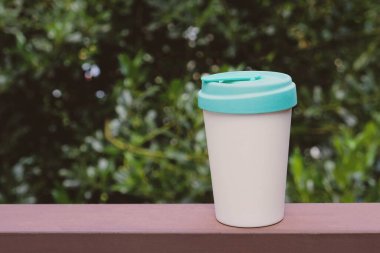 Yeniden kullanılabilir, çevre dostu, kapaklı bambu kabı, yakın çekim. Mesaj için yer var. Sıfır atık, sürdürülebilir yaşam tarzı konsepti. Plastik atıkları azalt. Kahveni kendin götür..