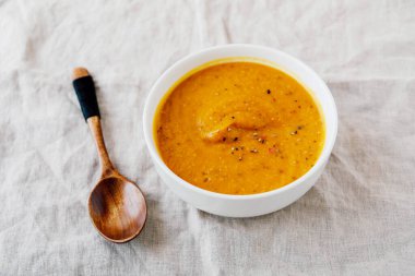 Beyaz arka planda sıcak baharatlı balkabağı çorbası, yakın plan. Ev yapımı sonbahar yemekleri. Popüler Şükran Günü yemeği..