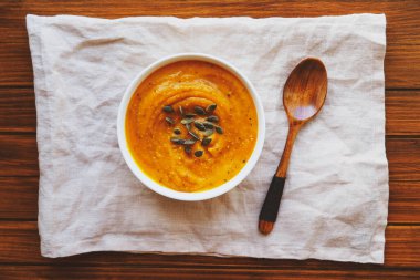 Kabak çorbası ahşap arka planda kabak tohumlarıyla servis edilir. Ev yapımı sonbahar yemekleri. Popüler Şükran Günü yemeği..