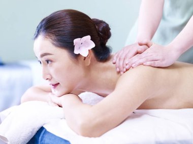 güzel bir genç Asyalı kadın masaj spa salonda alma yan görünüm.