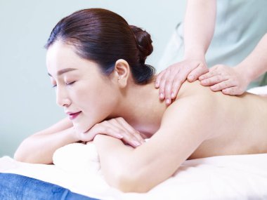 güzel bir genç Asyalı kadın masaj spa salonda, gözleri kapalı alan yan görünüm.
