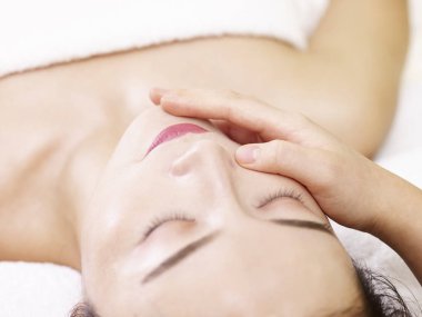 güzel genç Asyalı kadın yüz masaj spa salonda, gözleri kapalı alan Close-Up.