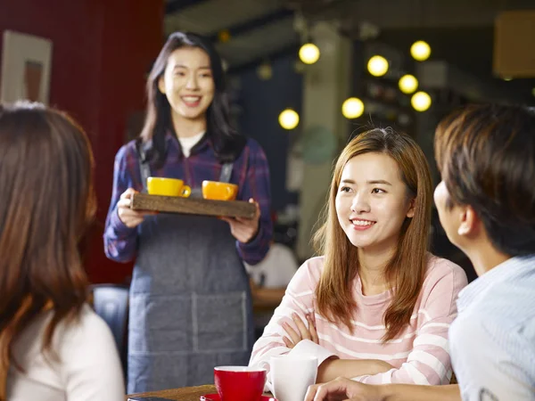 Três Felizes Jovens Asiáticos Adultos Sentados Mesa Conversando Enquanto Garçonete — Fotografia de Stock