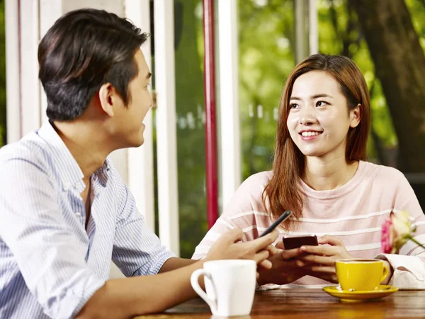 Happy Smiling Young Asian Couple Talking While Playing Mobile Phone — Stock Photo, Image