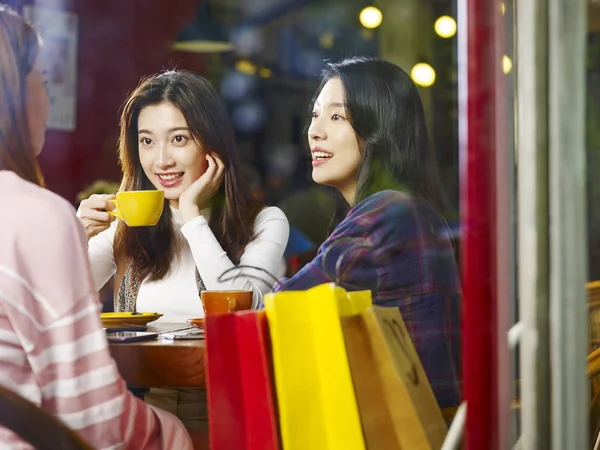 Три Счастливые Красивые Молодые Азиатские Женщины Сидящие Столом Болтая Кафе — стоковое фото
