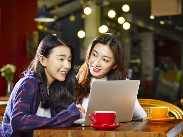Две Счастливые Молодые Азиатки Сидят Кофейне Смотрят Вместе Ноутбук — стоковое фото