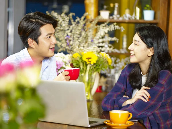 快乐的年轻亚裔夫妇聊天用笔记本电脑在咖啡店交谈 — 图库照片