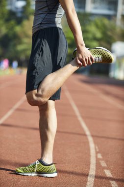 Genç Asyalı adam erkek atlet yolda bacak Germe kadar ısınma.