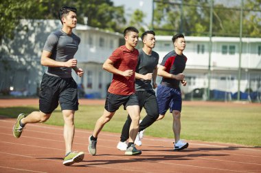 yolda, yan görünüm eğitim çalışan genç Asya Yetişkin sporcular.