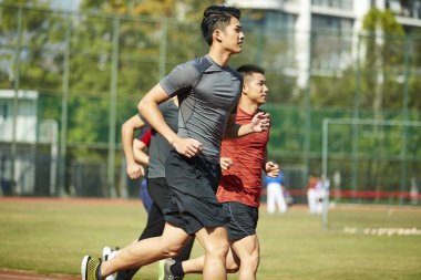 yolda, yan görünüm eğitim çalışan genç Asya Yetişkin sporcular.