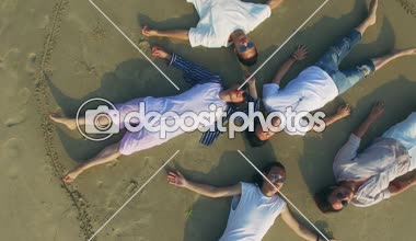 sırt üstü yatan genç Asya Yetişkin kum plaj gözleri kapalı, havadan görünümü. 