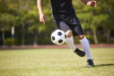 yakın çekim ayak topu futbol sahası üzerinde işleme Asya futbol oyuncusu vurdu.
