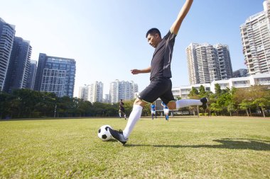 Genç Asyalı futbol futbolcu maç sırasında topu çekim
