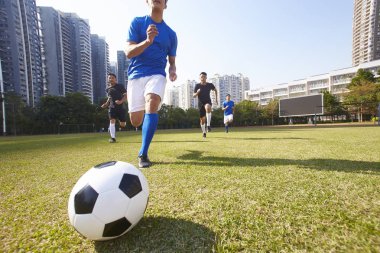 Genç Asya futbol futbol oyuncuları topu kovalarken bir maç sırasında
