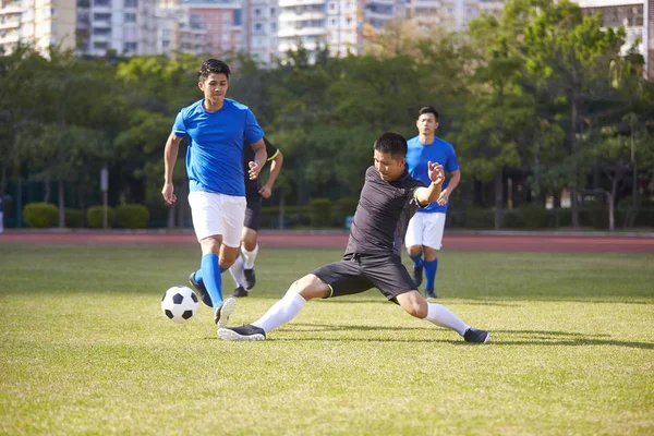 一群年轻的亚洲足球运动员在户外赛场上玩耍 — 图库照片