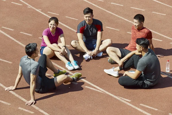 Grupo Jovens Asiáticos Atletas Falando Relaxando Pista Após Treinamento — Fotografia de Stock