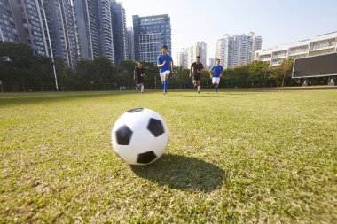 Genç Asya futbol futbol oyuncuları topu kovalarken bir maç sırasında
