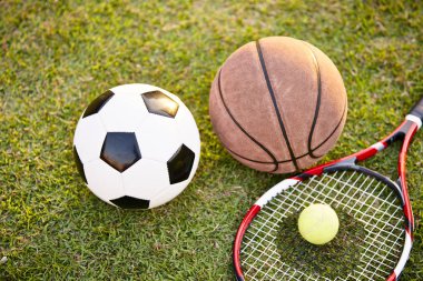 futbol futbol topu basketbol tenis top ve raket günbatımı, portre, çimlerin üzerine koydu