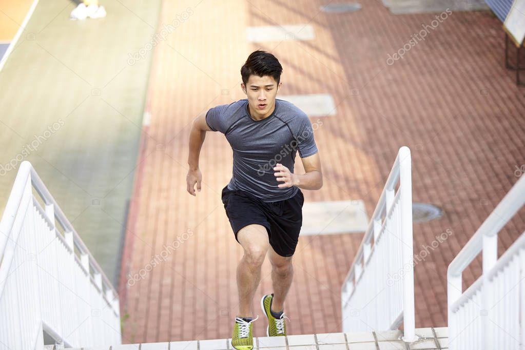 young asian man training running on steps outdoors